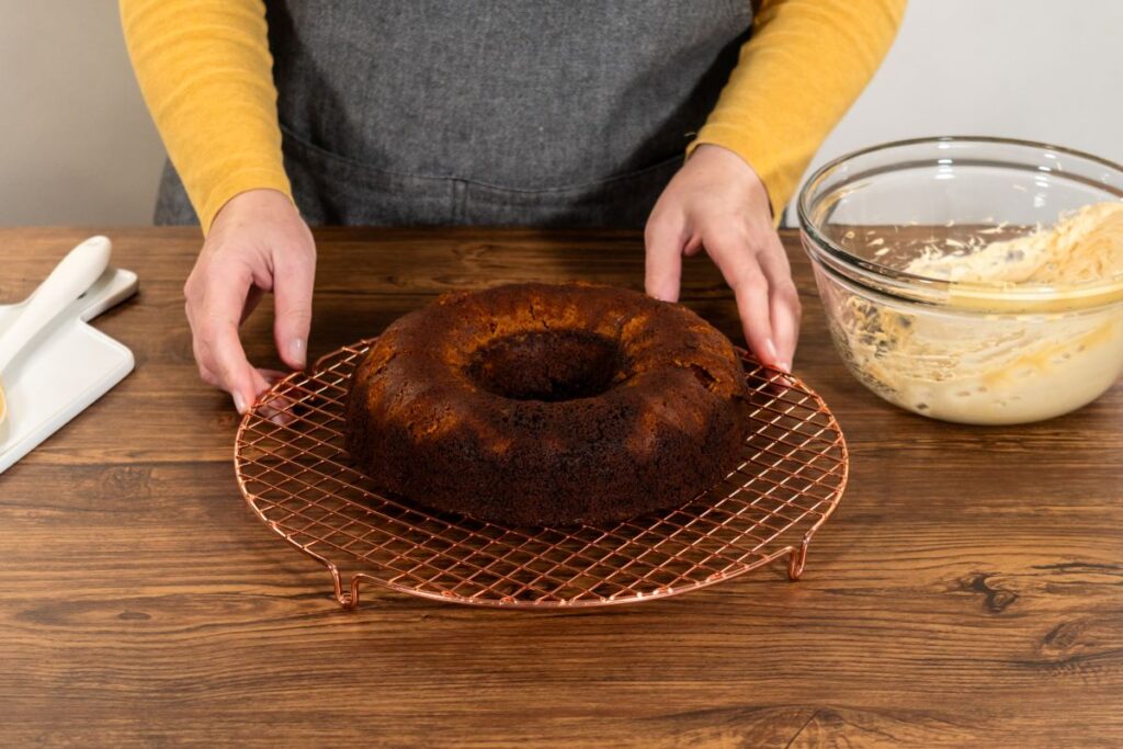 Baking a gingerbread Bundt cake on a cooling rack with caramel frosting ingredients