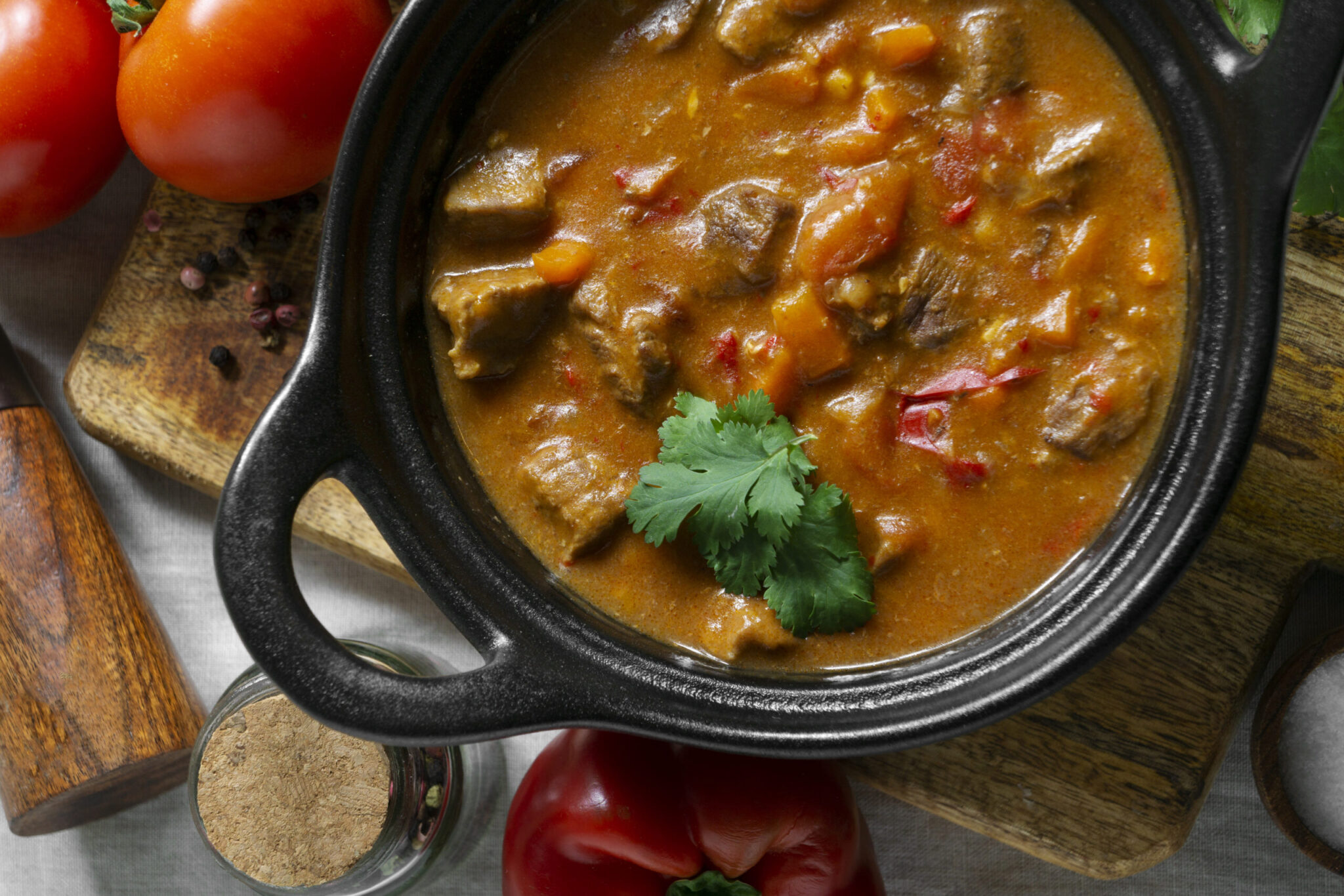 Close-up of a bowl of chicken and sausage gumbo with rice, garnished with fresh parsley."