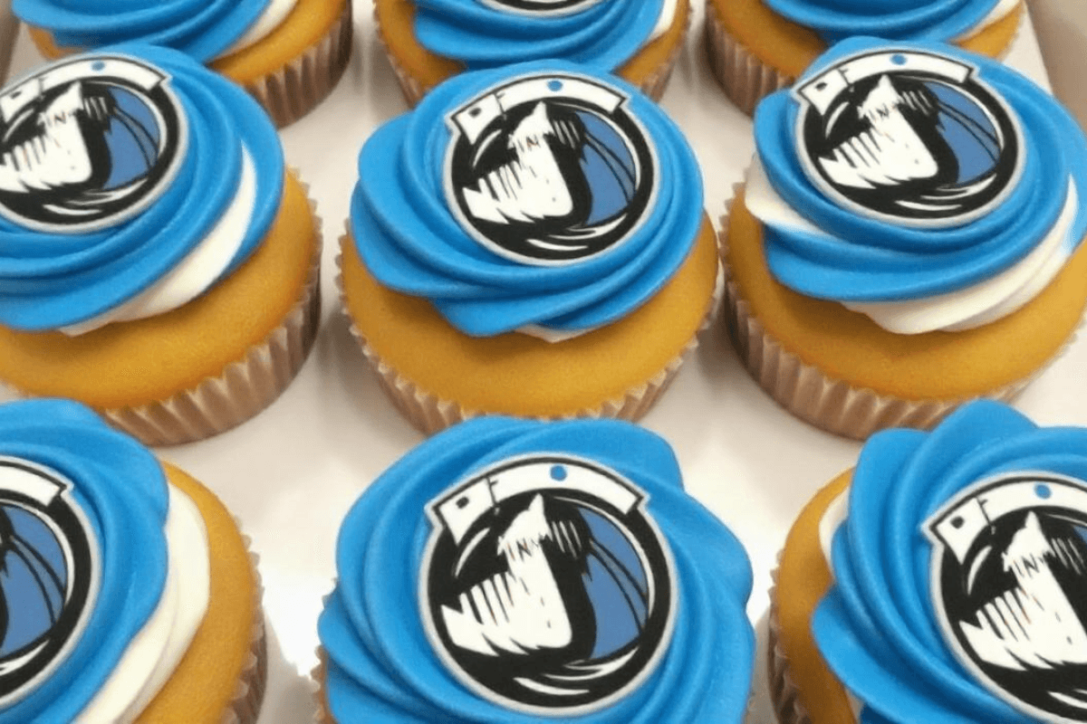 Decorated Mavs-themed cupcakes with blue and white frosting, featuring Dallas Mavericks logos, perfect for game day celebrations.