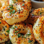 Homemade air fryer Bagel Bites topped with sesame seeds and fresh herbs, perfectly crispy and golden.